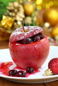 假日餐桌上的红烤苹果和小红莓图片
