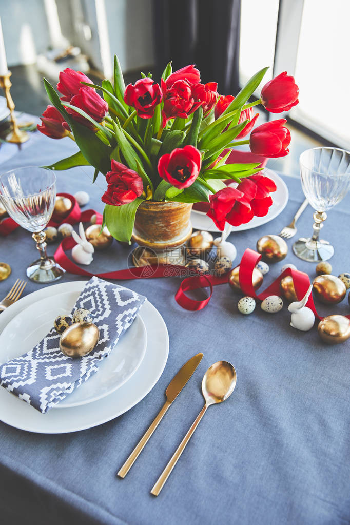 节日桌上红色郁金香和东方蛋花图片
