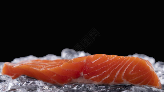 一片新鲜的鲑鱼肉片在黑图片