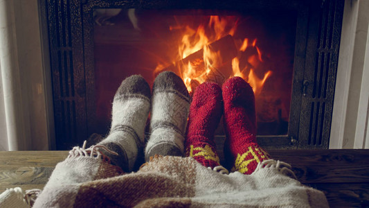 房子壁炉旁暖热的一对穿针袜子的夫图片