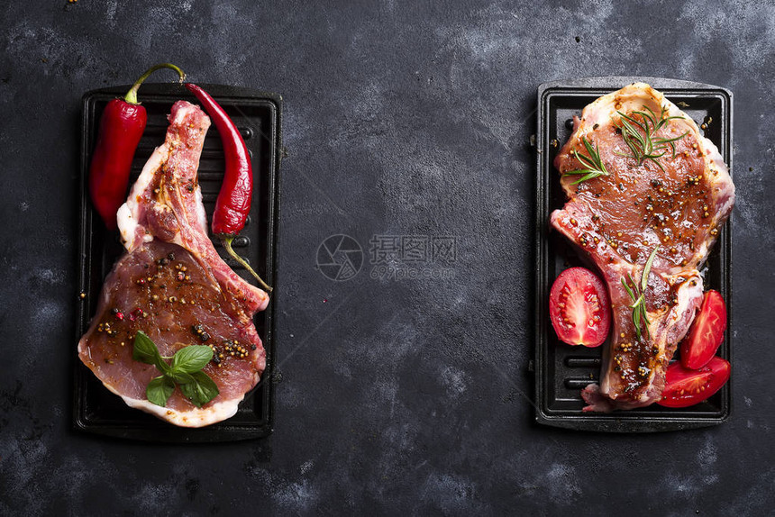 黑底原生肉猪肉牛排和草药及香料烹饪肉复制空图片