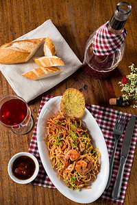 餐桌上的意大利面碗小麦面包和红酒图片