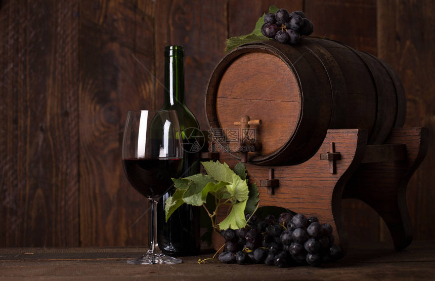 瓶红葡萄酒葡萄和木桶图片