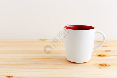 木桌上的白色和红色咖啡杯背景图片
