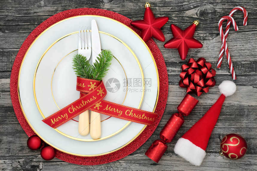 圣诞餐桌盘餐巾餐具冷杉丝带圣诞帽糖果手杖饼干和仿古木背景图片