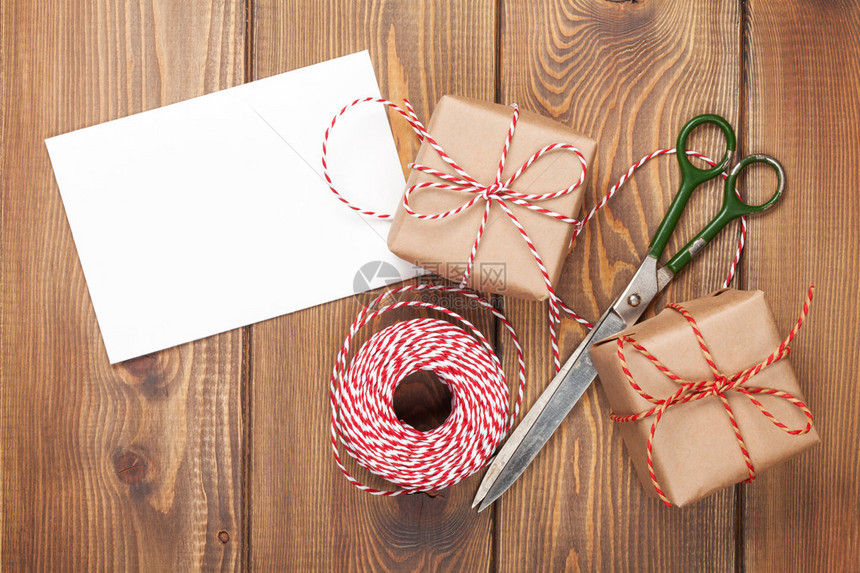 用贺卡盒子和剪刀在木桌上包装的礼物图片
