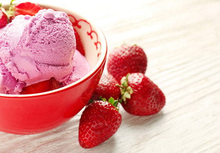 木制背景碗中的美味草莓冰淇淋图片