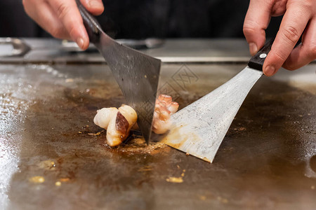在铁板烧日本厨师在餐厅烹饪和烧烤期间图片