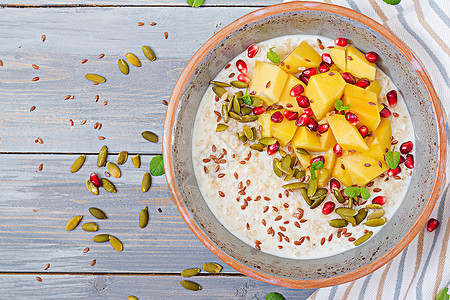美味健康的燕麦粥配芒果石榴和种子健康的早餐健身食品适当的图片