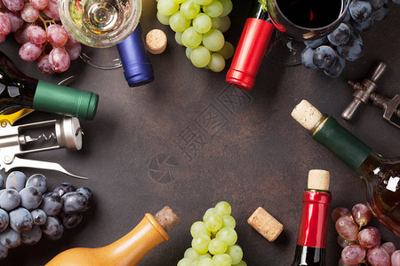 石桌上的酒瓶和葡萄带有空图片