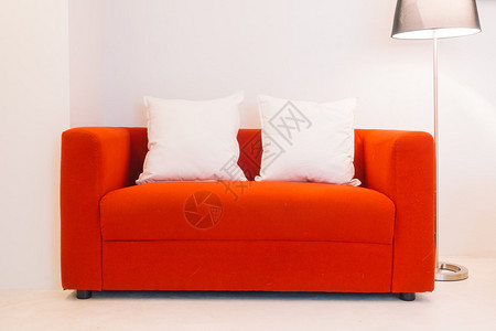 红沙发在室内内装有枕头和灯装饰图片