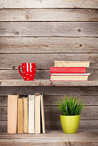 木架咖啡杯和植物上的旧书图片