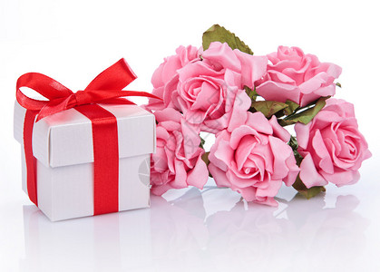 粉红花和礼物盒带红色丝带在白图片