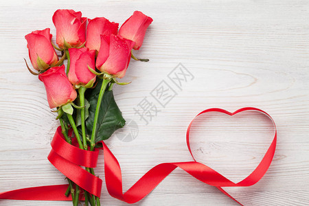 情人节贺卡与红玫瑰和心形丝带木制背景带图片