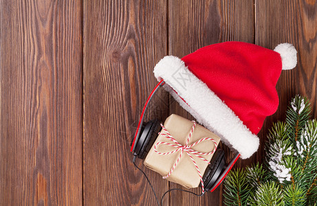圣诞礼物盒木制桌上有耳机和圣塔图片