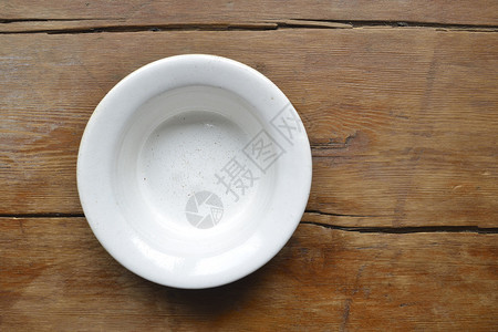 老式木桌上的白色陶瓷碗背景图片