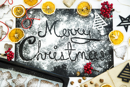 黑板上的圣诞题词在圣诞装饰姜饼和干橙图片
