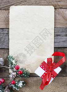 带圣诞礼物的纸页和木制背景图片