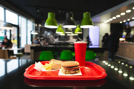 快餐店桌托盘上的快餐菜单快餐店的汉堡薯条和玻璃可乐快餐概念背景中的托盘背景图片