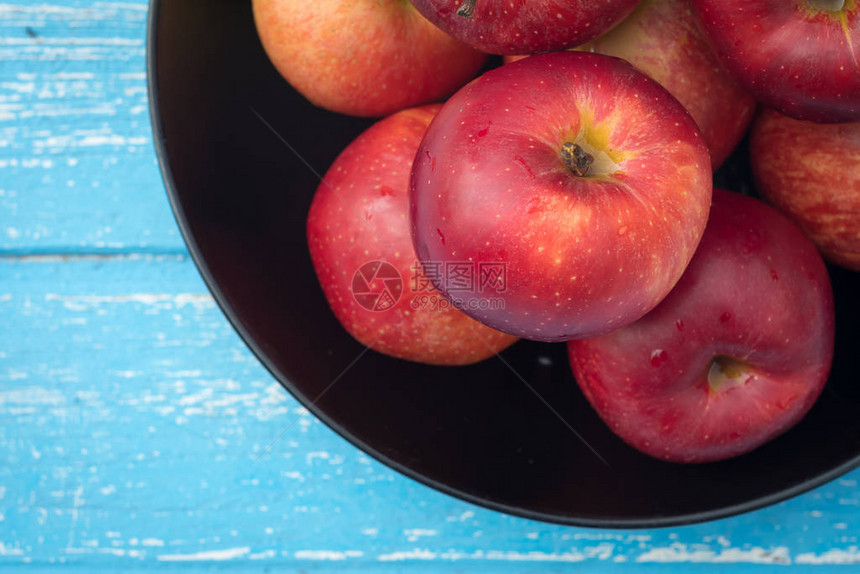 蓝色木桌上新鲜成熟的红苹果图片