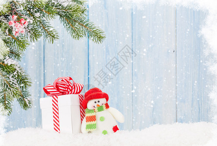 圣诞礼品盒雪人玩具和fir树枝带图片
