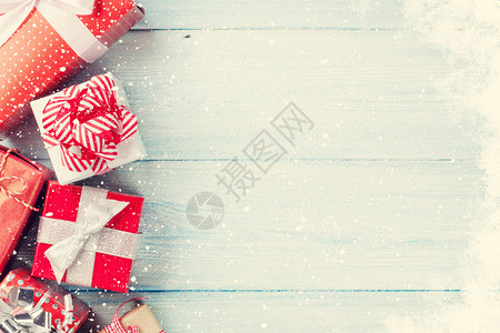 在木桌上的圣诞礼物盒与雪背景图片