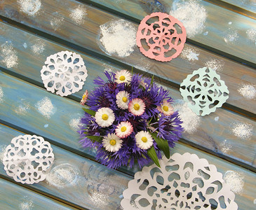 可爱的纸雪花和一束花放在蓝色木制桌子图片