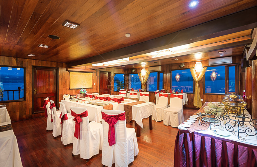 木墙门天花板和地板餐厅美丽优雅的室内设计开窗海景白色的椅子和带蝴蝶结的红丝带里面图片