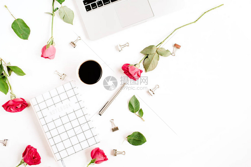 工作区配有笔记本电脑红玫瑰花咖啡杯笔记本和白色背景的夹子图片