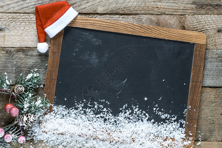 木制背景上的黑板和圣诞装饰品图片