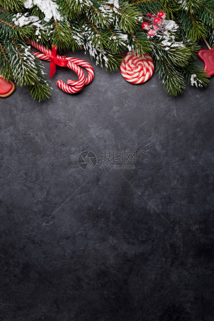 圣诞卡片上贴着甜食和树枝的石头背景图片