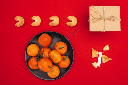 红表面上的幸运饼干和橘子背景图片