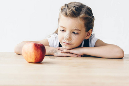小女学生坐在桌边红苹果图片