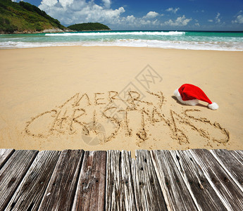 圣诞快乐在热带海滩的圣诞老人帽子上刻着图片