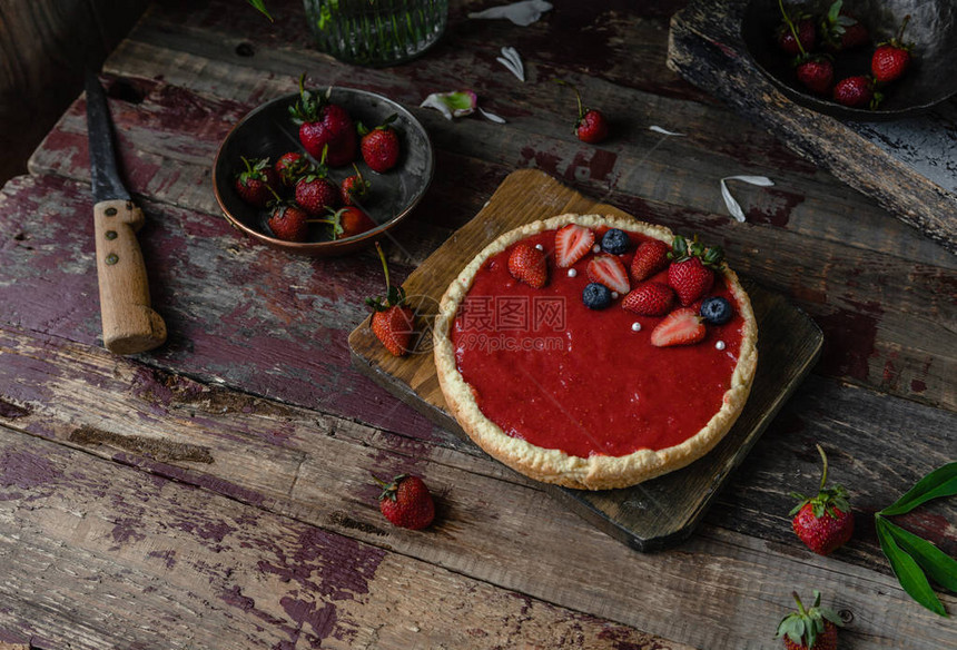 木桌上美味的熟草莓派图片