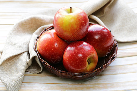 红成熟的苹果在木制桌子背景图片