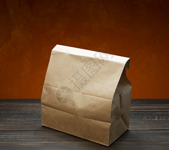 棕色牛皮纸袋午餐或食物在红色背景的木桌上用复制空间包装纸袋午餐食品袋或食品外卖背景图片