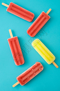 蓝色背景中的草莓和柠檬冰棒图片
