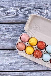 在托盘的复活节彩蛋木制背景上的染色鸡蛋庆祝复活图片
