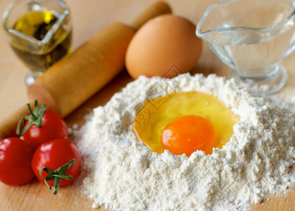 准备意大利面团木制餐桌上的面粉橄榄油鸡蛋水和木图片