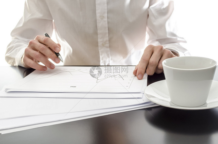 商人在办公桌上分析财务报告图片