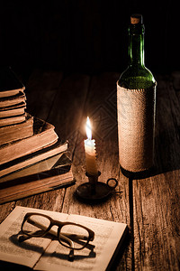 古老阅读概念一堆过时书籍烧蜡烛红酒图片