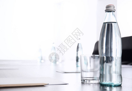 为在会议厅举行的商业会议准备的装有一瓶水的表图片