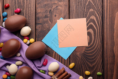 巧克力复活节鸡蛋配有彩色糖果和木图片