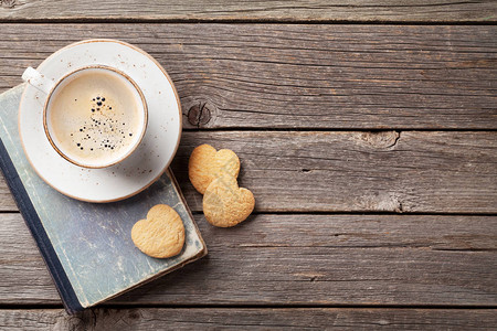 木桌上的咖啡杯和心形饼干图片