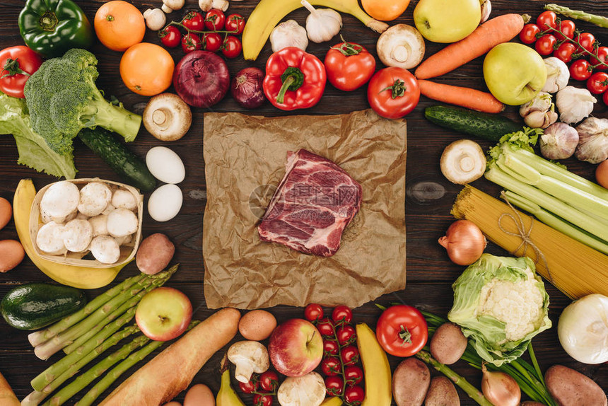 木制桌上蔬菜和水果之间生肉图片