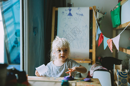 可爱的女婴在家中绘画图片