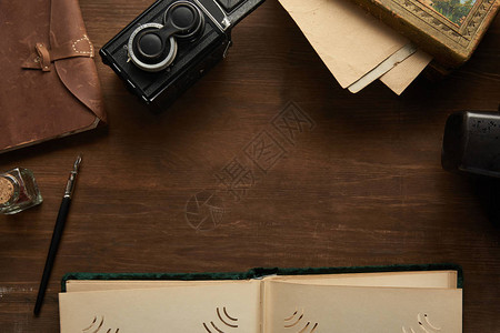 老式相机相册绘画木桌上的钢笔的顶视图图片