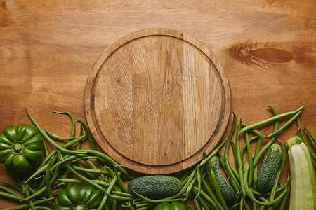 木桌上有绿色蔬菜的切菜板图片