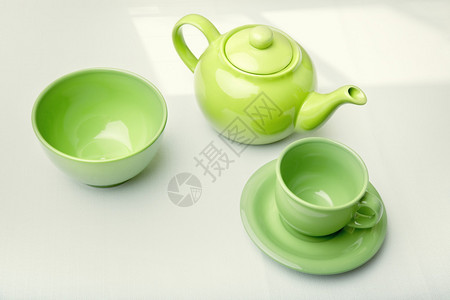 绿色茶壶桌上有杯子和图片